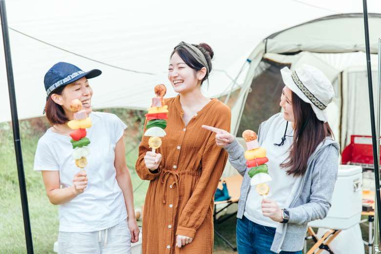 キャンプにてバーベキューを楽しむ女性3人