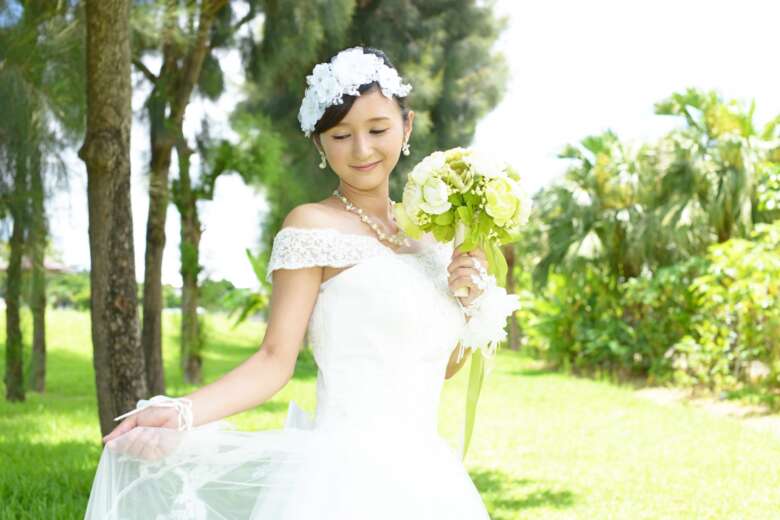 植物を背景にした洋装の美しい花嫁